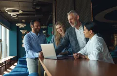 Team smiling at laptop